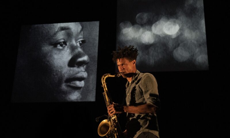 Lamine Diane au saxophone devant des images d'archives, Kay! Lettres à un poète disparu, Festival Off d'Avignon 2026