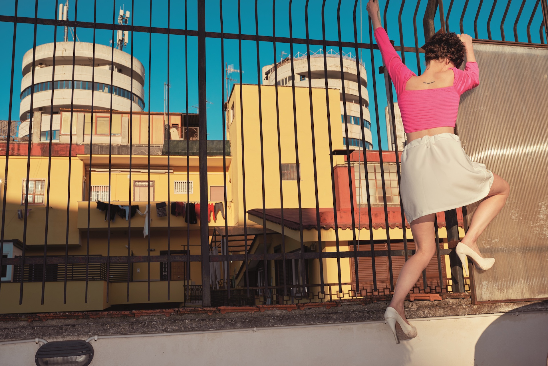 Femme escaladant une grille sur un toit, visuel de la saison Captives 2026-2027 de l'Opéra Grand Avignon, Kourtney Roy